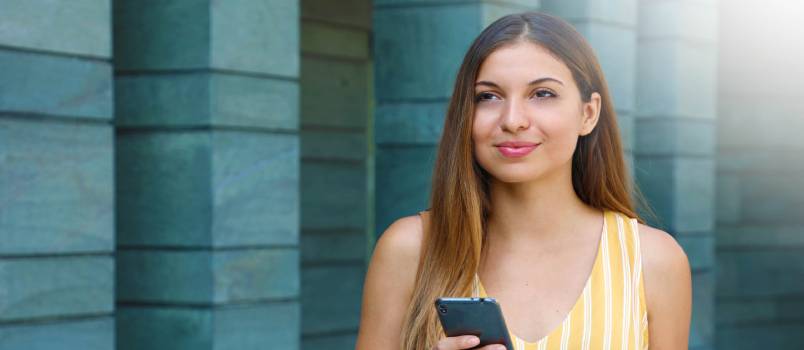 Mujer joven enviando mensajes de texto en el teléfono inteligente