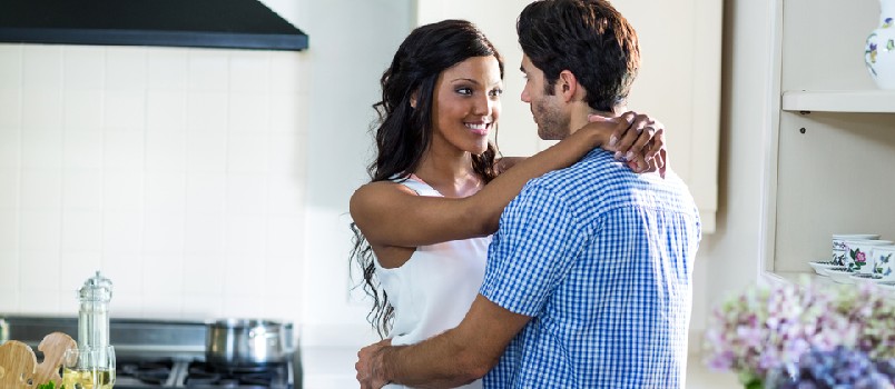 hombres y mujeres de humor romántico en la cocina divirtiéndose