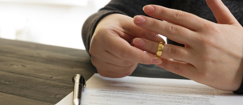 Presentación de documentos de divorcio o acuerdo prematrimonial preparados por un abogado y un anillo de dama