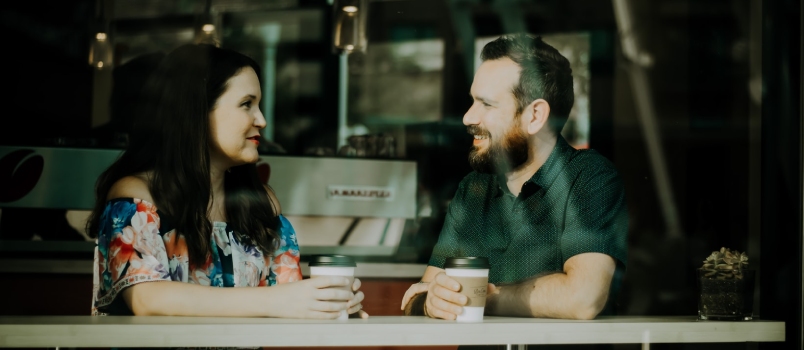 Joven y atractiva pareja hermosa teniendo una cita juntos en el café