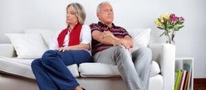 Longitud total de una pareja mayor sentada en un sofá después de una pelea