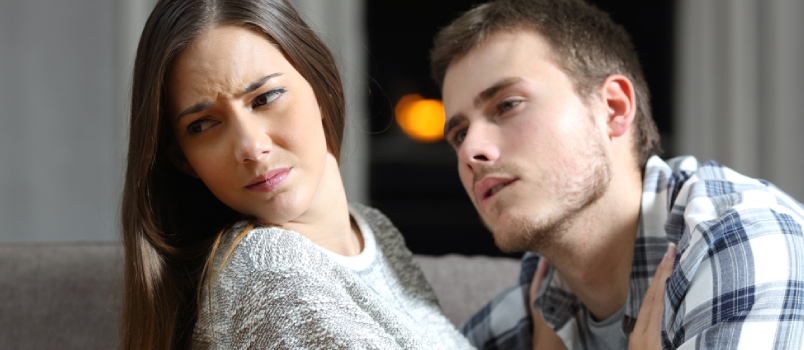 Hombre insistente tratando de tener sexo y su novia preocupada negándolo en un sofá en la noche en casa