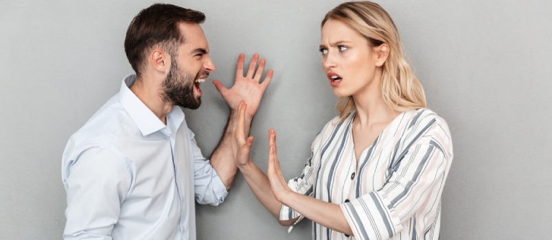 Foto de una pareja irritada, hombre y mujer con ropa informal, teniendo problemas y discutiendo aislados sobre fondo gris