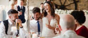 Una pareja de recién casados ​​está socializando con los invitados a la comida de su boda